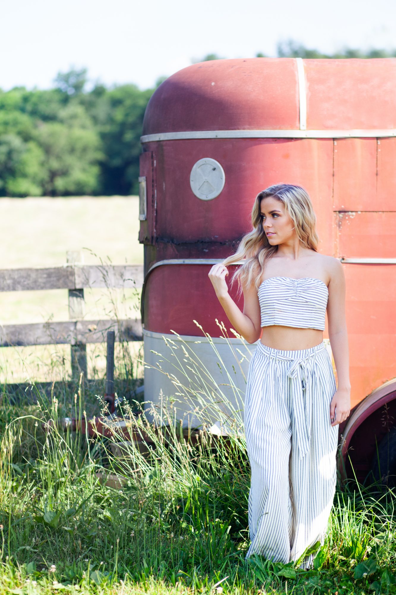 louisville senior girl at blackacre farm standing by rustic red and white trailor