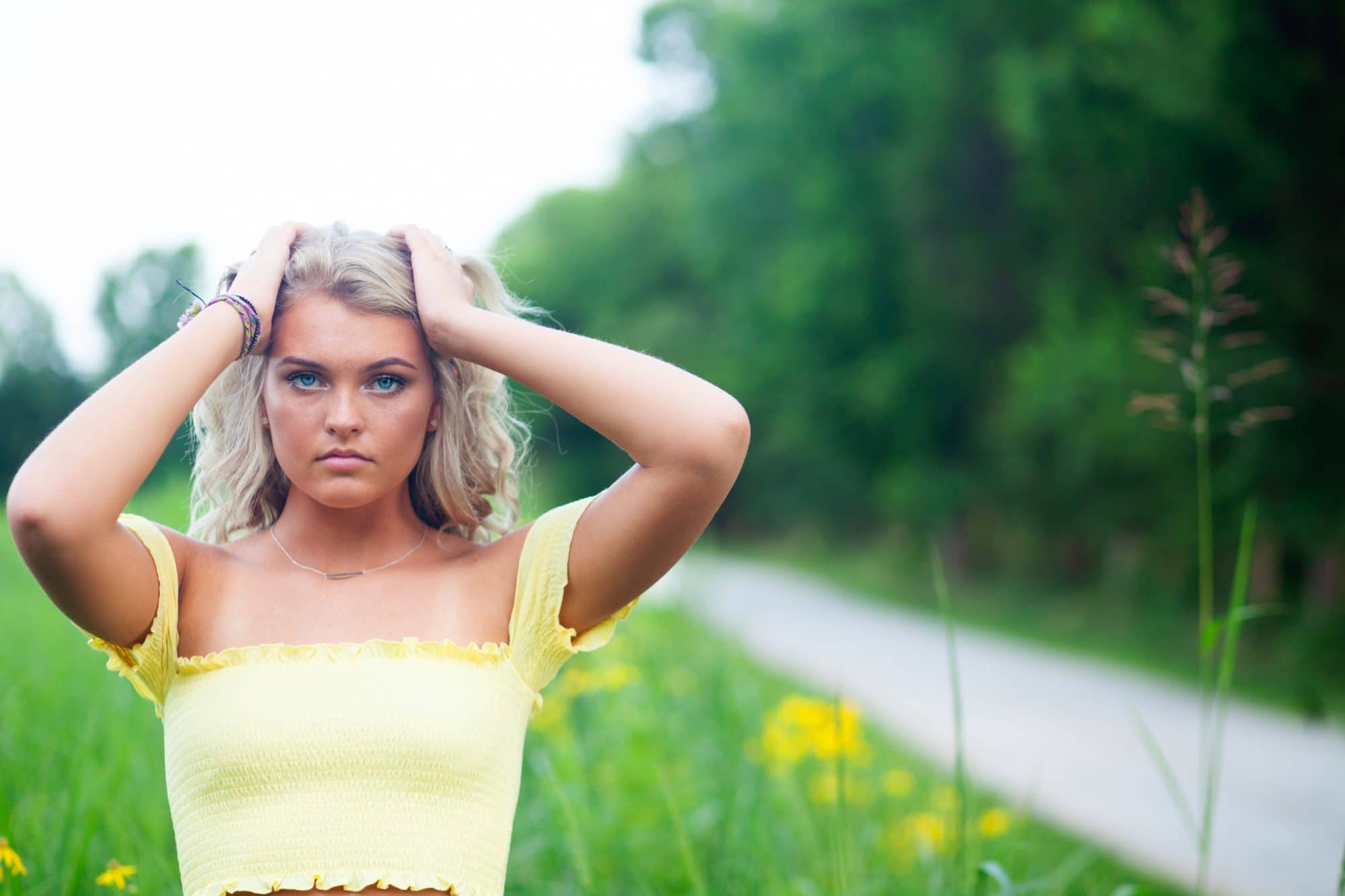 louisville high school senior at blackacre nature preserve wearing yellow shirt next to yellow flowers